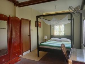 a bedroom with a canopy bed with a window at O'hamok family in Battambang