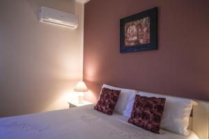a bedroom with a bed with two pillows on it at Casa Piano del Re in Partinico +10 photos