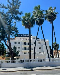 un edificio blanco con palmeras delante en Vas Málaga Ciudad, en Málaga