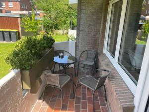 ノルデンにあるApartment am Stadtgartenのバルコニーに椅子とテーブルが置かれたパティオ