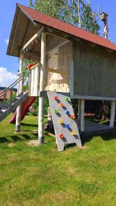 a play structure with a slide in the grass at Blisko Lasu in Ustrzyki Dolne