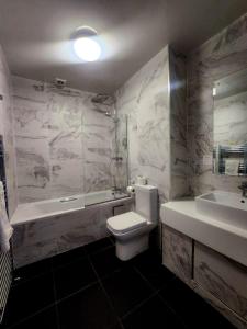 ein Badezimmer mit einem WC, einer Badewanne und einem Waschbecken in der Unterkunft Keppels Head Hotel in Portsmouth