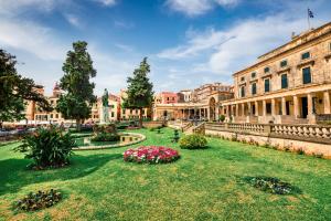 a courtyard with flowers in front of a building at Mon Repos Deluxe Apartment by Corfuescapes in Anemómylos +8 photos