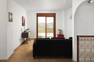 a living room with a couch and a television at Plaza Iglesia in Frigiliana