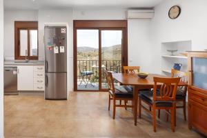 a kitchen with a table and a stainless steel refrigerator at Plaza Iglesia in Frigiliana