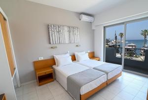 a bedroom with a bed with a view of the ocean at Jasmine Hotel in Kos Town