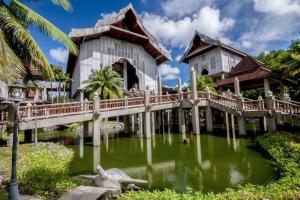a house with a bridge over a body of water at Sumai Hotel Apartment in Kuala Terengganu
