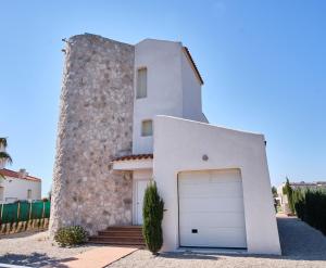 a white house with a garage in front of it at Villa Almadrava in Tarragona
