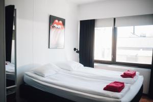 ein Schlafzimmer mit einem Bett mit roten Handtüchern darauf in der Unterkunft Rock Hotel Salo in Salo