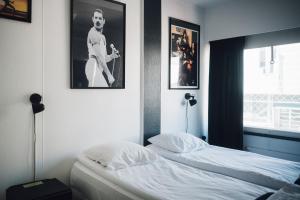 ein Schlafzimmer mit einem Bett und einem Bild eines Mannes in der Unterkunft Rock Hotel Salo in Salo