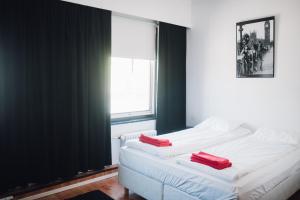 ein Schlafzimmer mit einem Bett mit zwei roten Kissen darauf in der Unterkunft Rock Hotel Salo in Salo