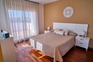 a bedroom with a large bed and a large window at Villa Almadrava in Tarragona +29 photos