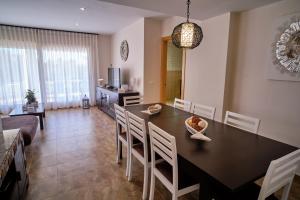 a dining room and living room with a table and chairs at Villa Almadrava in Tarragona