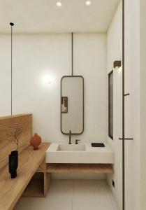 W łazience znajduje się biała umywalka i lustro. w obiekcie Celia Apartments w mieście Vasilikos