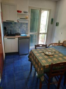 una cocina con mesa y una cocina con mesa y sillas en Villa Verdemare Naxos, en Giardini Naxos