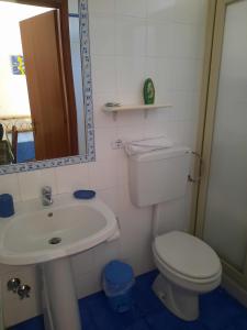 a bathroom with a sink and a toilet and a mirror at Villa Verdemare Naxos in Giardini Naxos