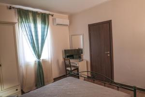 a bedroom with a bed and a window and a desk at Casa Piano del Re in Partinico