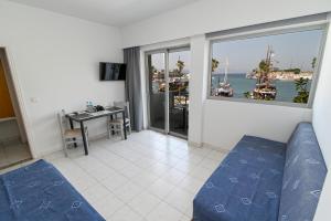 een woonkamer met een bank en uitzicht op de oceaan bij Jasmine Hotel in Kos-stad