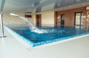 a pool with a water fountain in a building at Porta Mare Resort & SPA Apartament Dziwnów in Dziwnów
