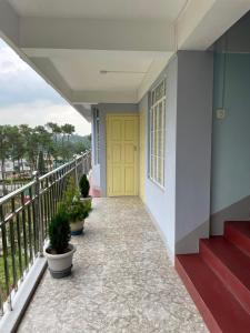 a porch with a yellow door and some plants at Keeon Private Room Top in Shillong