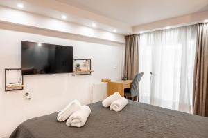 ein Hotelzimmer mit einem Bett und zwei Handtüchern in der Unterkunft ΕΥ. CENTRAL STUDIO in Larisa