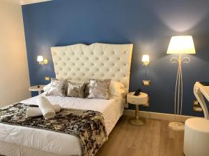 ein Schlafzimmer mit einem großen Bett mit blauer Wand in der Unterkunft Hotel Ca' D'Oro in Bibione