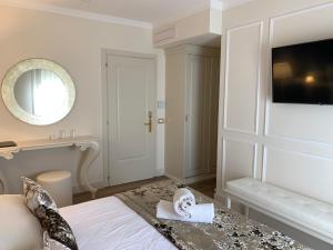 een slaapkamer met een bed met een spiegel en een tafel bij Hotel Ca' D'Oro in Bibione