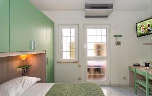 1 dormitorio con paredes verdes y blancas y 1 cama en Hotel Mariani, en Lido di Camaiore