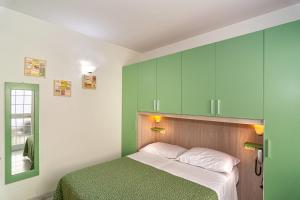 1 dormitorio con armarios verdes y 1 cama en Hotel Mariani, en Lido di Camaiore