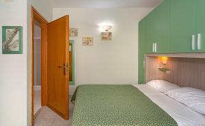 1 dormitorio con 1 cama grande con colcha verde en Hotel Mariani, en Lido di Camaiore