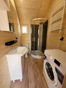 a bathroom with a sink and a washing machine at Domki Wakacyjne "Morskie Wrota"Karwieńskie Błota in Karwieńskie Błoto Drugie +29 photos