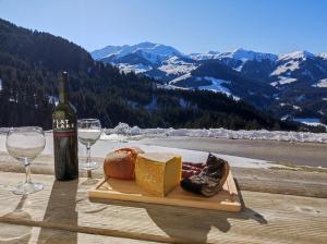 a table with a plate of cheese and a bottle of wine at Ferienwohnung in Panorama Alleinlage Kitzbüheler AlpenWILD63 by FeWo-Plan in Schwarzenau