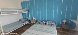Mési的住宿－VILLA KARA - Bed and Breakfast，一间卧室设有两张双层床,拥有蓝色的墙壁。