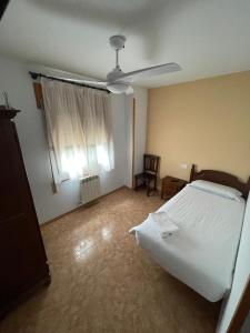 a bedroom with a bed and a ceiling fan at Hostal La Rurala Estopanyà in Estopiñán
