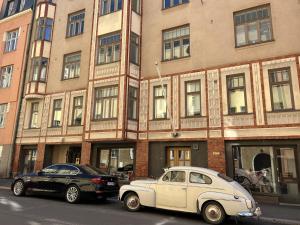 een oude witte auto geparkeerd voor een gebouw bij Luotsi 1911 Suite in Helsinki
