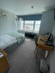 1 dormitorio con 1 cama y escritorio con ordenador en The Royal Albion en Broadstairs