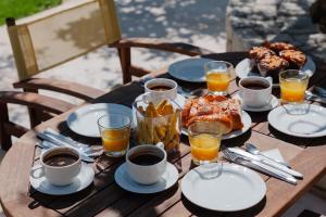 uma mesa de madeira com comida e bebidas para o pequeno-almoço em Villa Amarantos - Private pool em Stamnoí