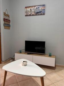 - un salon avec une table basse blanche et une télévision dans l'établissement Adrian’s apartment, à Orikum