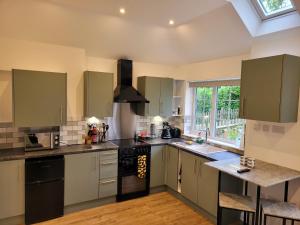 een keuken met witte kasten en zwarte apparaten bij The Annexe at Albourne in Albourne
