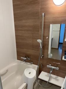uma casa de banho com uma banheira, um WC e um espelho. em Populasunupuri - Vacation STAY 62945v em Otaru