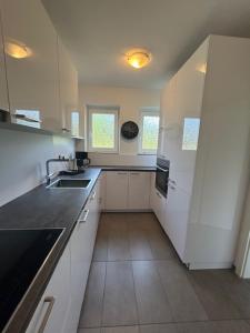 a white kitchen with a sink and a refrigerator at Landhaus il Cavallino in Sassenberg
