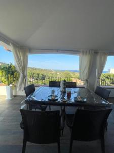 una mesa y sillas en una habitación con vistas en Casa vacanza Lentisco D Sardegna Ogliastra, en Tertenìa