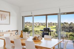 a dining room with a table and chairs and a large window at Saltwater Breeze Retreat in Cowes