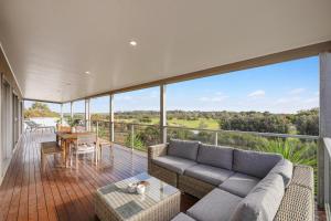 a living room with a couch and a table on a balcony at Saltwater Breeze Retreat in Cowes