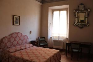 a bedroom with a bed and a window and a table at Palazzo Trevisani in Porto San Giorgio