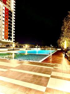 una piscina notturna in una città di Alanis Residence Master Bedroom a Sepang