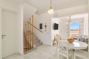 a dining room and living room with a table and chairs at Paros Sea View Eco - Aetherian Ciel Villas, Aktaia in Mármara