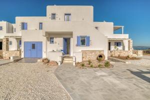 a large white house with a blue door at Paros Sea View Eco - Aetherian Ciel Villas, Aktaia in Mármara