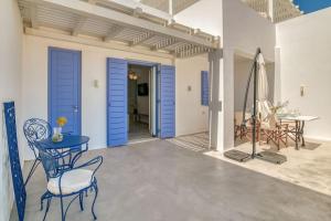 a patio with blue doors and a table and chairs at Paros Sea View Eco - Aetherian Ciel Villas, Aktaia in Mármara