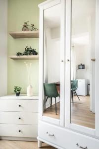 a white cabinet with a mirror in a room at Cocon aux portes de Paris in Clichy